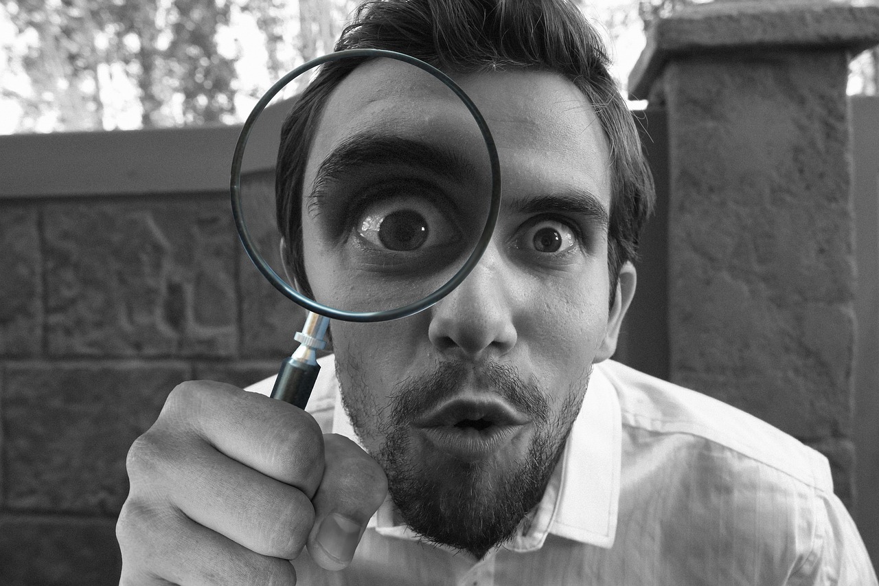 man looking through magnifying glasses