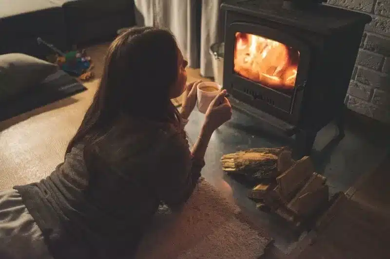 woman alone by a fireplace